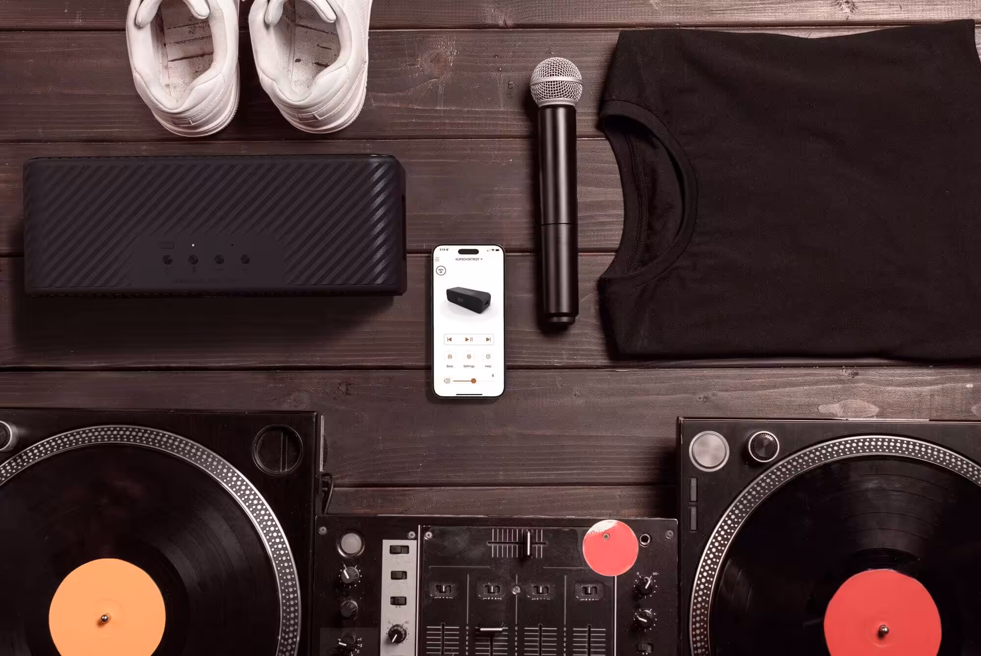 Hochwertige DJ- und Streaming-Ausrüstung mit Turntables, Mixer, Lautsprecher, Mikrofon, Smartphone und Kleidung für einen perfekten Musikabend.