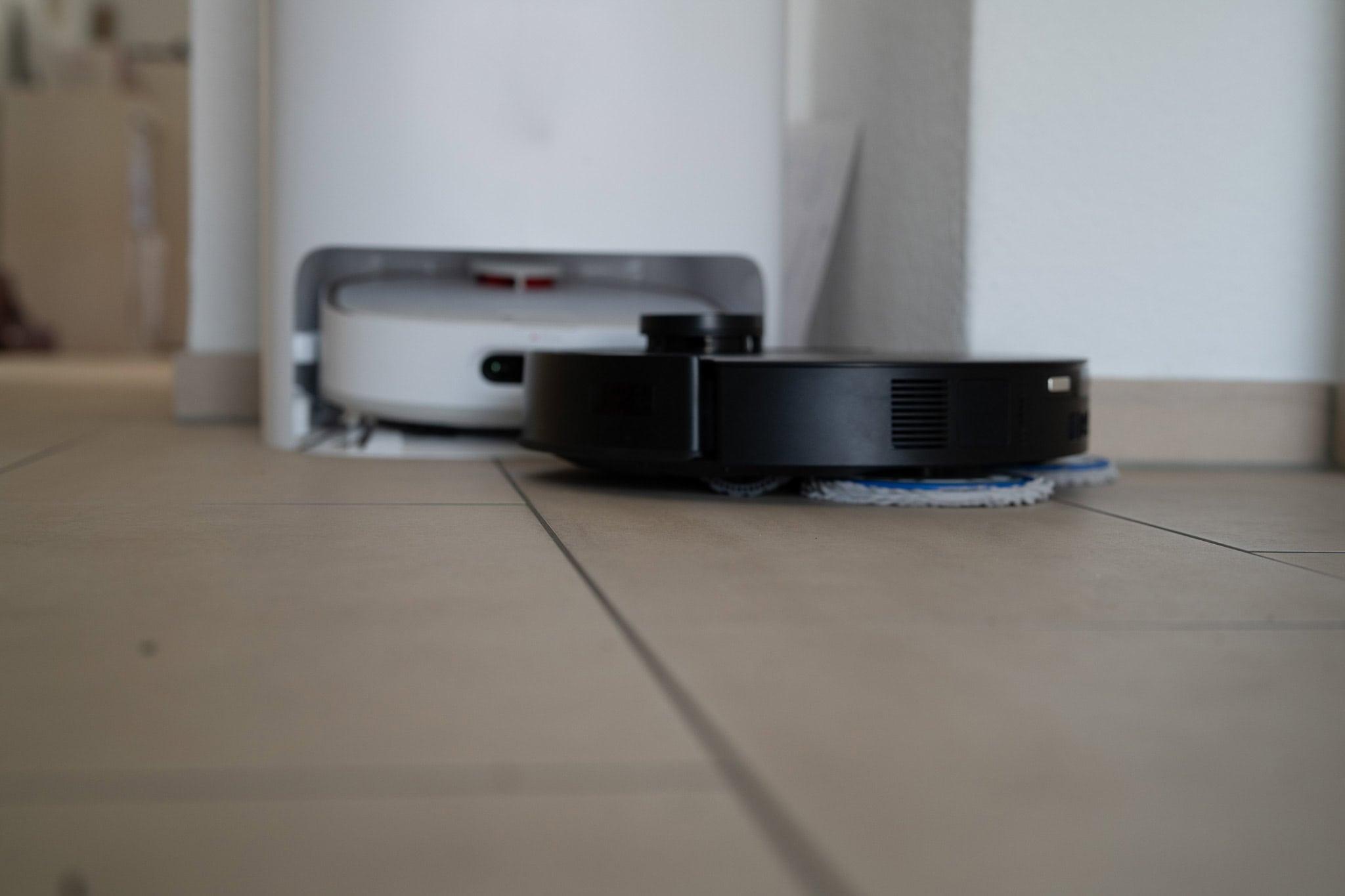 Staubsaugerroboter in Aktion beim Reinigen eines bodentiefen Raums. Modernes Smart Home Zubehör für automatisierte Hauspflege und innovative Streaming-Technologien.