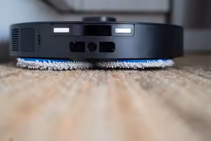 Staubsaugerroboter bei der Reinigung auf einem Holzboden, zeigt modernes Smart Home Gerät für automatische Hausreinigung.