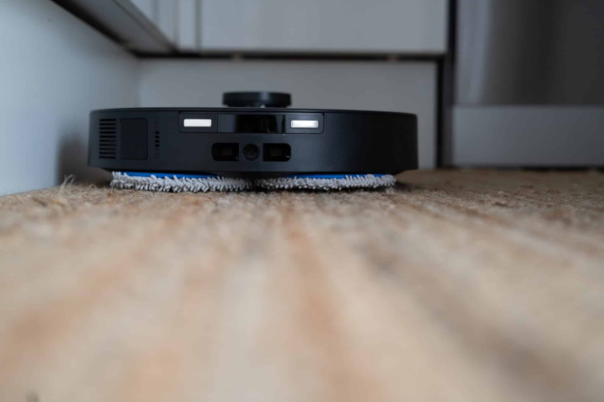 - Roboter Staubsauger bei der Reinigung eines Teppichbodens in einem modernen Smart Home.