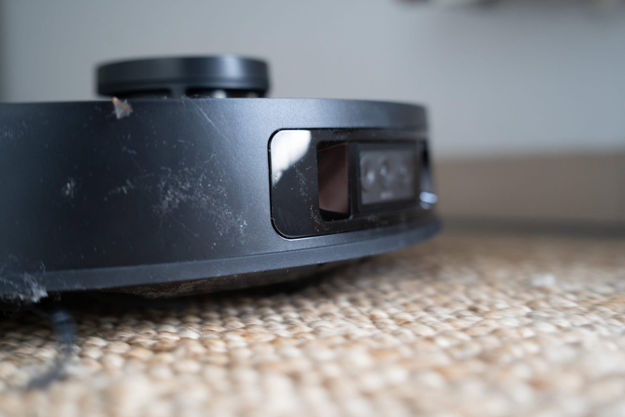 Staubsaugerroboter auf glattem Holzboden, immobil, Nahaufnahme, Smart Home Geräte, Automatisierte Bodenreinigung, Technologie im Haushalt.