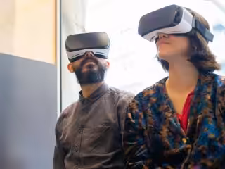 Einsatz von Virtual-Reality-Headsets durch ein Mann und eine Frau in einem modernen Büro.