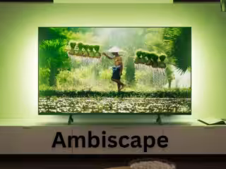 Hochauflösendes Smart TV im Wohnzimmer mit ambienter grüner Beleuchtung, zeigt ein naturnahes Bild mit einem traditionell arbeitenden Landwirt. Perfekt für Smart Home, Streaming und moderne Hardware-Integration.