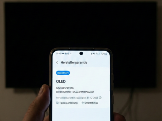 Smartphone zeigt Firmware-Details eines OLED-Fernsehers, wichtig für einfache Geräteverwaltung und Smart Home Integration.