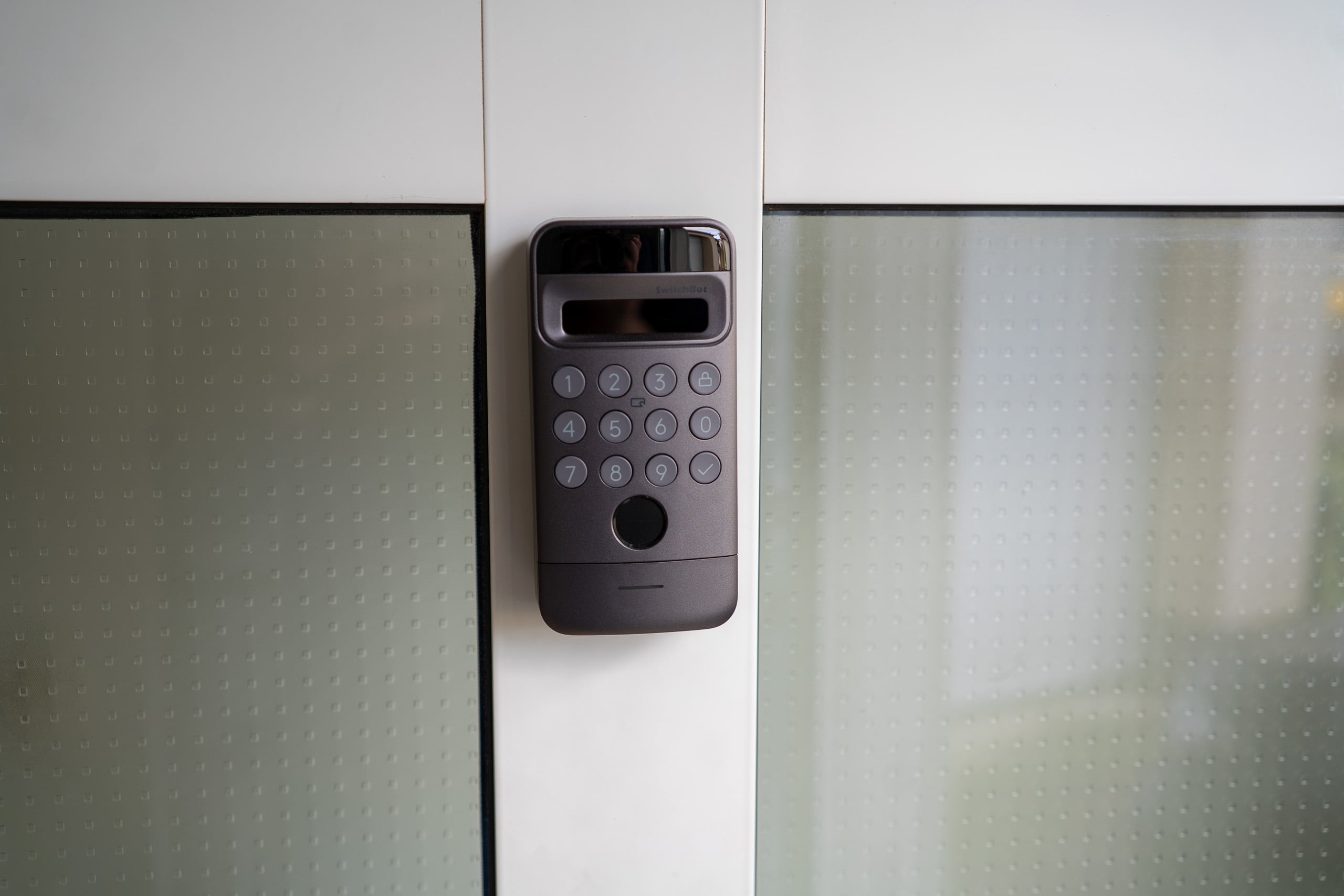 Türschlösser auf der IFA 2026: Aqara zeigt Aliro, kaufen kann man bisher nur eines Keypad eines smarten Türschlosses neben einer Tür mit Milchglasfüllung
