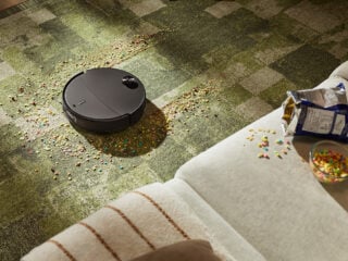 Roborock Qrevo Edge 2 mit ausgefahrenem FlexiArm an Moebelkante