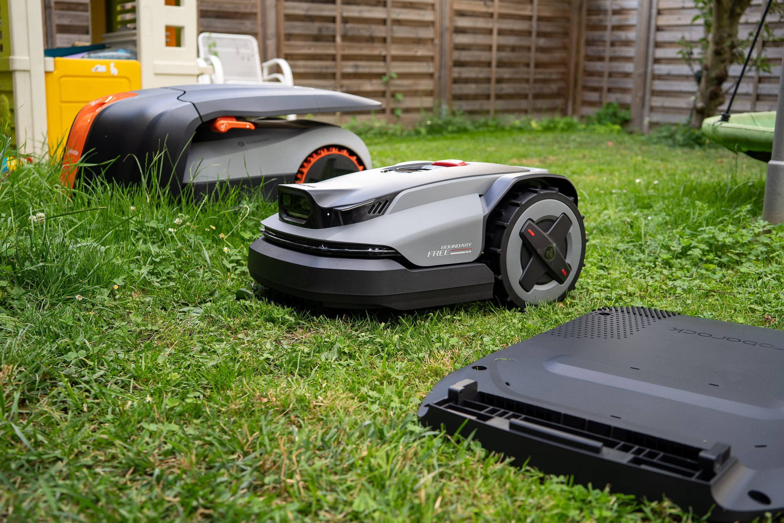 Roborock RockMow S1 im ersten Eindruck: der Saugroboter-Riese mäht jetzt Roborock RockMow S115 vorne, dahinter der Navimow i208 in der Ladestation im Garten