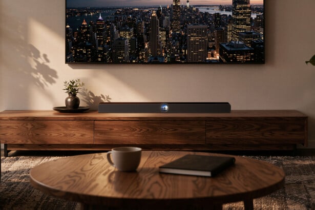 WiiM Bar Dolby-Atmos-Soundbar mit rundem Touch-Display unter einem Wandfernseher