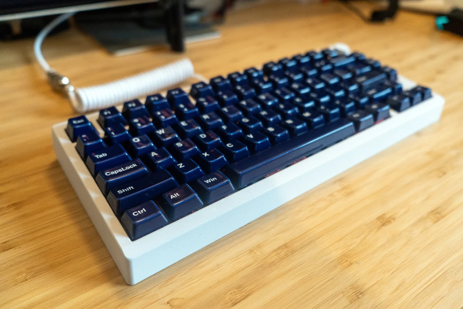 Tastatur mit schwarzen Keycaps auf Holzoberfläche, mechanisches Keyboard, deutsche Tastaturbelegung, benutzerdefinierte Tastenkappen.