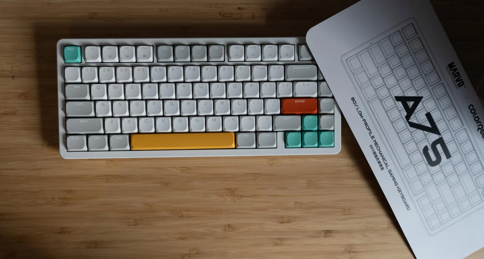 Thocky, schlank und eine NuPhy-Alternative: MARVO ColorReco A75 im Test Auffällig gestaltete mechanische Tastatur mit bunten Keycaps auf einer Holzplatte.