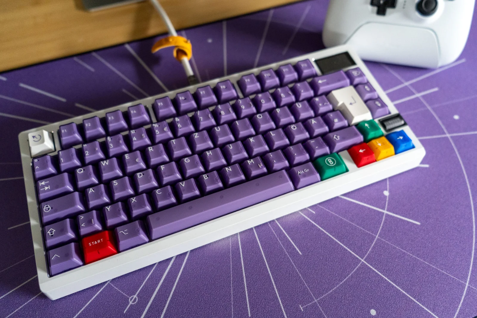 Bunte Tastatur mit lila Keycaps auf einem Gaming-Setup.
