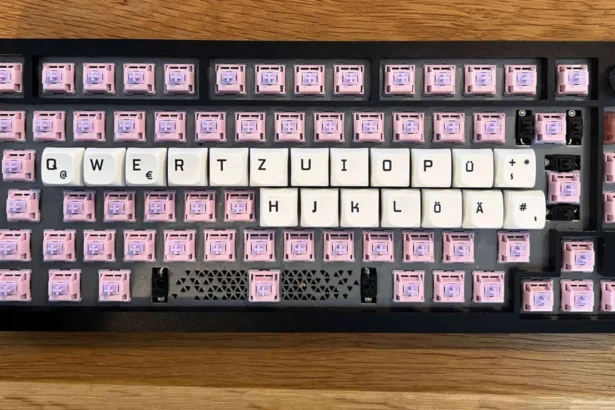 Edelstahl-Tastatur mit pinken Custom-Keycaps und weißen Tastenkappen in deutscher Layout.