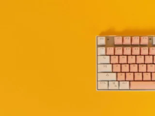 Bunter mechanischer Tastatur-Set mit rosa und weißen Tastenkappen auf gelbem Hintergrund.