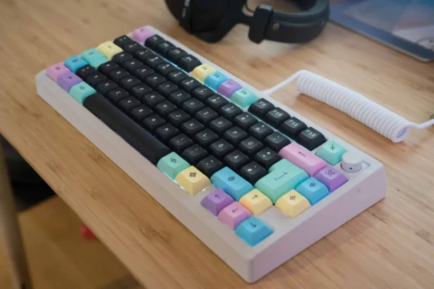 Bunte mechanische Tastatur mit Pastell-Keycaps auf Holzschreibtisch.