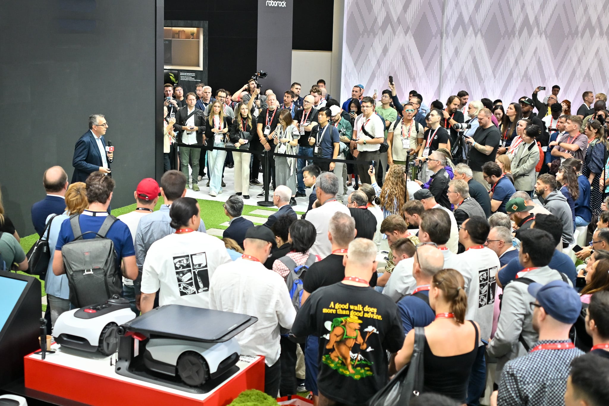 Zwei Mähroboter auf einem Podest am Roborock-Stand der IFA 2026, davor drängt sich die Presse