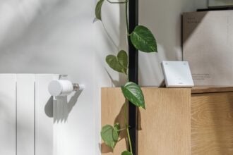 Netatmo Heizkörperthermostat ORIGINAL am Heizkörper, daneben das Thermostat ORIGINAL im Regal