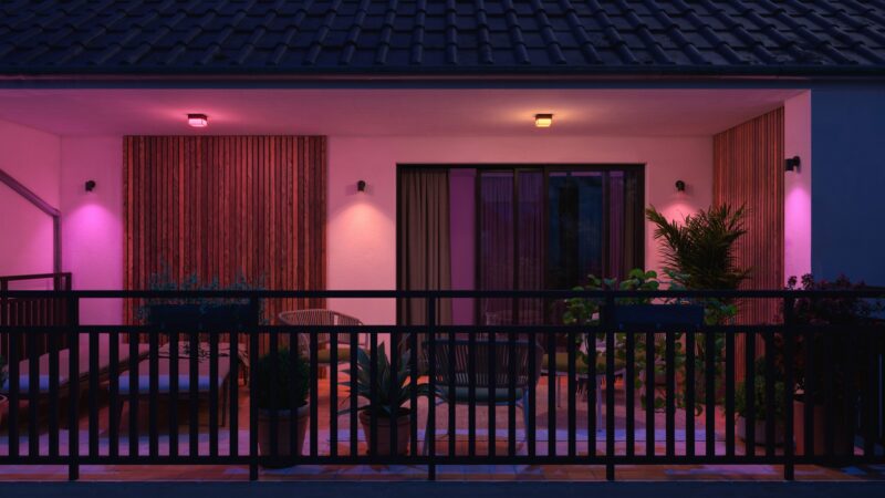Philips Hue Scenova als Deckenleuchte unter einem Vordach, darunter Wandspots an der Hauswand (Bild: Philips Hue)