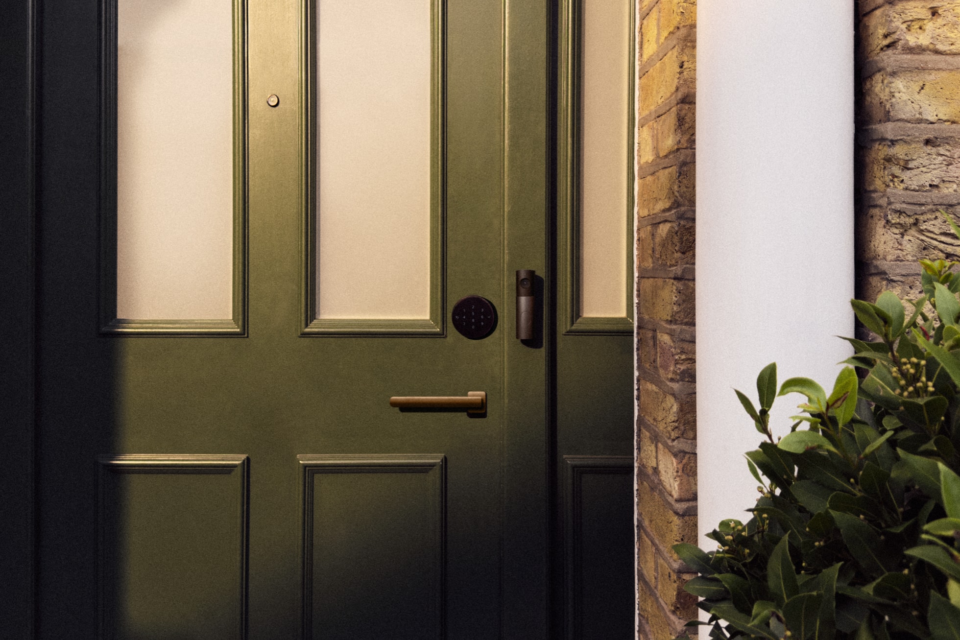 Grüne Haustür mit dem LG Smart Deadbolt Lock und der LG Video Doorbell aus der Apple Home Collection