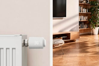 Hama Heizkörperthermostat mit Matter over Thread an einem weißen Heizkörper, dahinter ein Wohnzimmer mit Holzboden