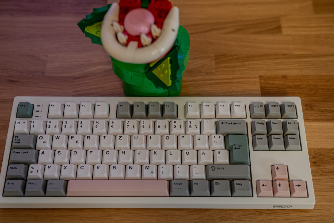 Epomaker TH87 Test: 100 Euro, deutsches Layout, und mir fehlt nichts Epomaker TH87 ISO-DE frontal auf dem Holztisch