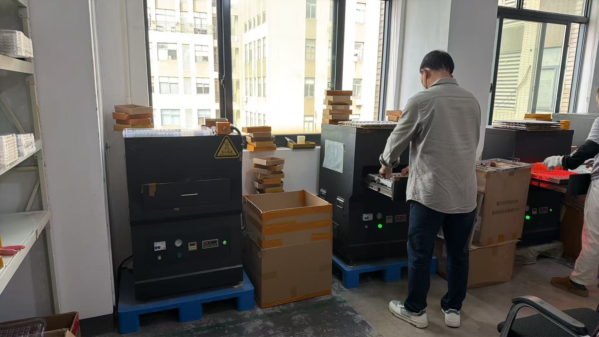 SIMPOCUBIC Produktion: Mitarbeiter zieht ein Tablett mit Keycaps aus dem Thermotransfer-Ofen
